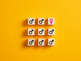 One female gender symbol with male symbols on wooden blocks. Gender discrimination in employment, recruitment or workplace