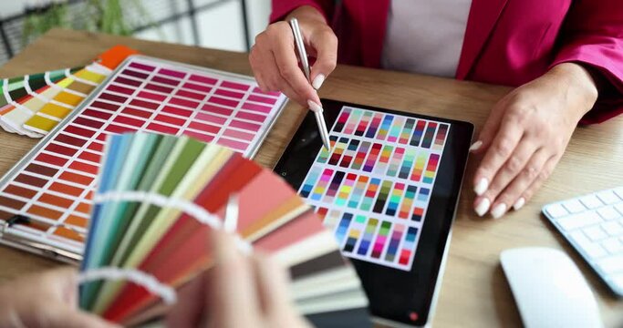 A woman in the office looks at color samples from a palette