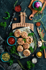 Grilled medallions wrapped in bacon. in a pan, ready to eat. On a black concrete background. Top view.