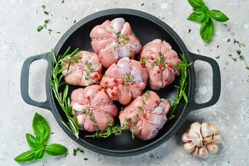 Turkey fillet with spices and rosemary in a pan, ready to cook. Barbecue. On a black concrete background. Top view.