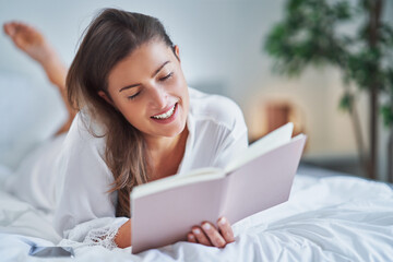 Brunette woman on bad with notepad or book