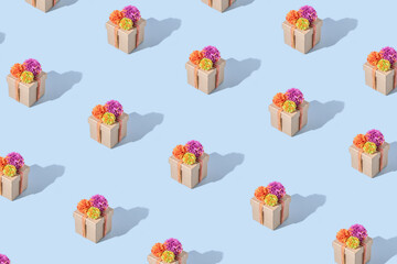 Minimal eco friendly gift box packaging pattern on blue background. Sustainable fashion delivery concept. Winter birthday present, christmas aesthetic. Reusable package with pink, orange yarn bow.