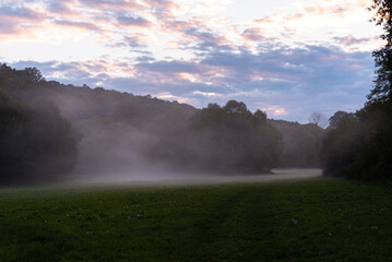 Amazing misty meadow in September sunset 
