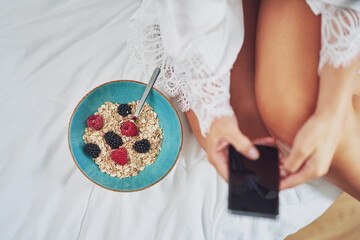 Nice brunette on bed wit cereal breakfast with phone