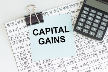 CAPITAL GAINS text on sticker with pen on white background