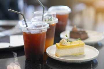 Piece of Bakery butter Cake Cream Lemon and chocolate Flavor with Iced Americano Coffee.