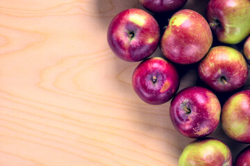 Concept for an simple autumn background. Close-up of fresh, organic apples on a wooden table. Flat lay, top view. Copy space.