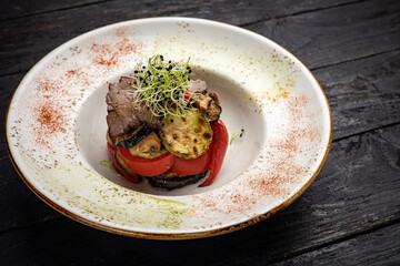 grilled meat with vegetables and spices on a black background
