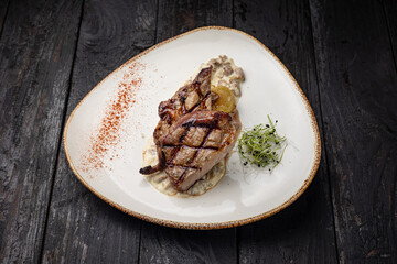 grilled meat with vegetables and spices on a black background
