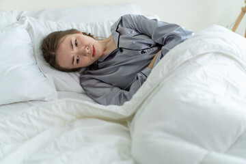 Caucasian beautiful sick girl in pajamas get up from sleep in bedroom. 