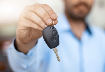 Close up of male hand holding car key. Auto purchase and rental concept