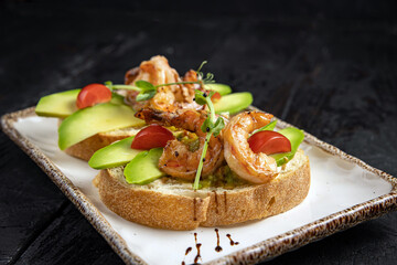 Bruschetta with seafood and greens on a white plate.
