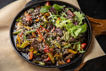 grilled meat with vegetables and spices on a black background
