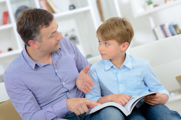 Father and son reading a book