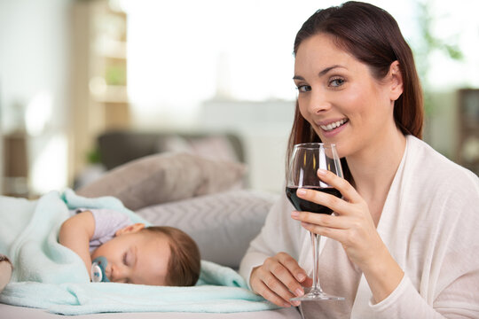 Woman Drinking Alcohol While Baby Sleeps