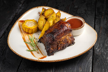 grilled meat with vegetables and spices on a black background
