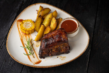 grilled meat with vegetables and spices on a black background
