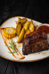 grilled meat with vegetables and spices on a black background
