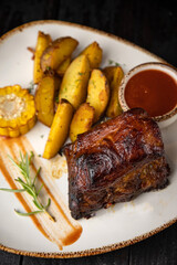 grilled meat with vegetables and spices on a black background
