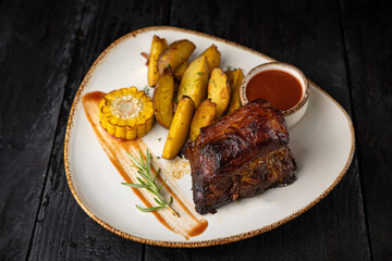 grilled meat with vegetables and spices on a black background
