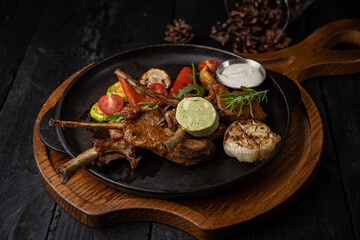 grilled meat with vegetables and spices on a black background
