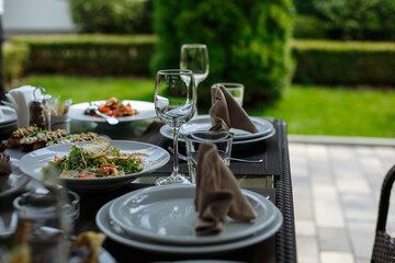 A table with beautiful dishes and prepared dishes on the summer terrace