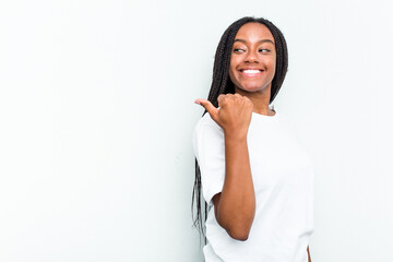 Young African American woman isolated on white background points with thumb finger away, laughing...