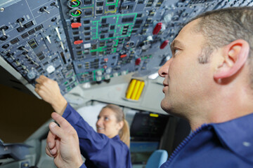 female apprentice operating cockpit controls