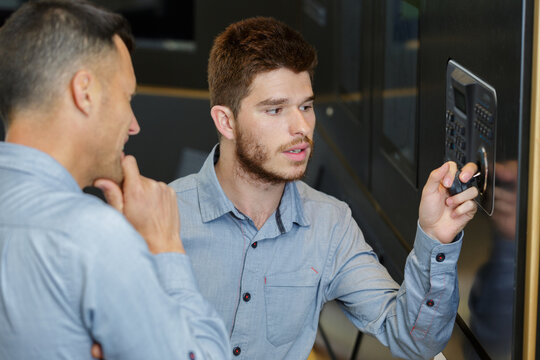 worker failing to open safe to his colleagues amusement - Powered by Adobe