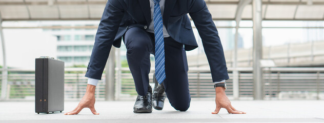 Businessman set in start running position prepare to fight in business race.