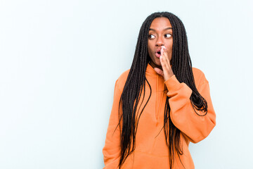 Young African American woman with braids hair isolated on blue background being shocked because of...
