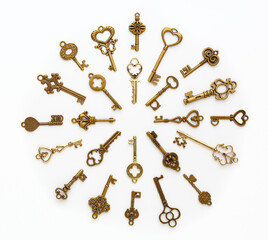 Old keys laid out in a circle shape on white background