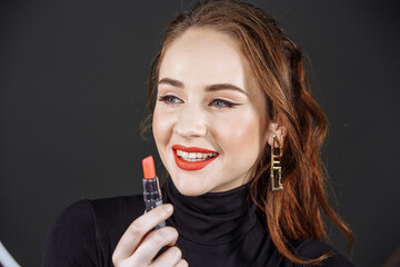 Obraz premium A girl with dark hair on a dark background with bright makeup