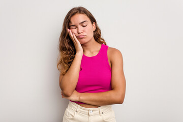 Young caucasian woman isolated on blue background who is bored, fatigued and need a relax day.