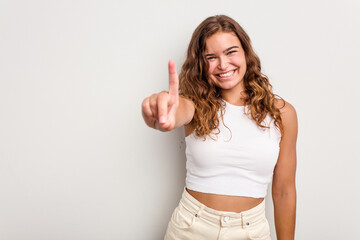 Young caucasian woman isolated on blue background showing number one with finger.