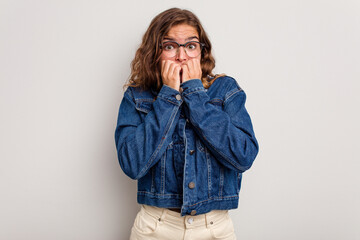 Young caucasian woman isolated on blue background biting fingernails, nervous and very anxious.