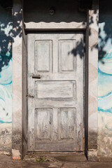 Fototapeta na wymiar Old wooden door in sunlight. Entrance to the house