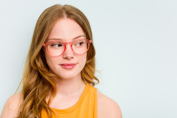 Fototapeta premium Portrait of pretty young caucasian wearing glasses woman isolated on blue background