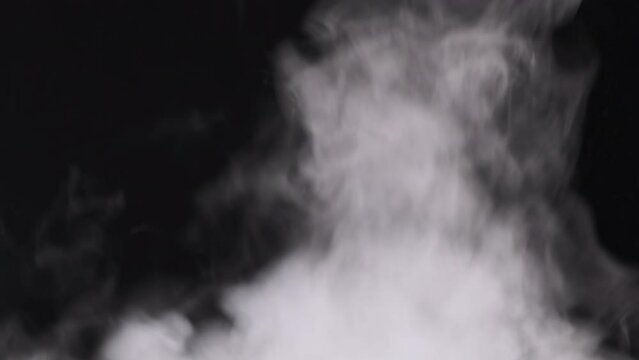 Realistic smoke or vapor clouds rise up, use in composite and video editing. Special effect, texture, footage. Smoke atmosphere fog overlay on black background. Abstract particles of steam texture. 4K