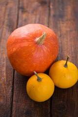 three small pumpkins on a wooden background