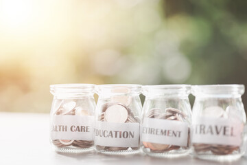 Message in a piece of paper and coins in a glass jar, money saving ideas, financial growth, retirement preparations, managing savings for different goals in the future, creating spending habits.