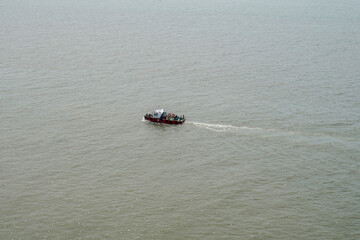 Boat crossing the sea water and left white line behind it at Surabaya, Indonesia on August 2022