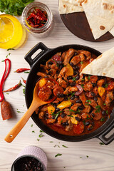 Pork stew with chorizo and black beans. Served with orange and seasoned with hot chili peppers. Perfect with tortillas.