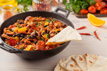 Pork stew with chorizo and black beans. Served with orange and seasoned with hot chili peppers. Perfect with tortillas.