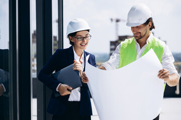 Business woman with architect talking on the roof of the construction building