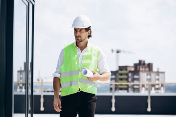 Business man in helmet standing on the roof of the building