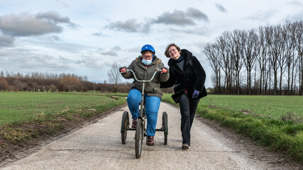 Crying girl with Down Syndrome driving the tricycle in the Flanders fields