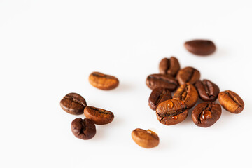 a little scattered  roasted coffee beans  on white isolated background