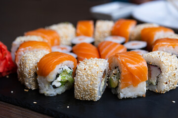 Sushi set close-up on black board. Traditional Japanese seafood
