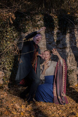 Vampire man wearing victorian suit and woman are afraid of the sun's rays. Vintage medieval concept style.